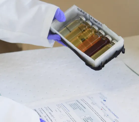 Expert dans un laboratoire avec une boite d'échantillons d'huile